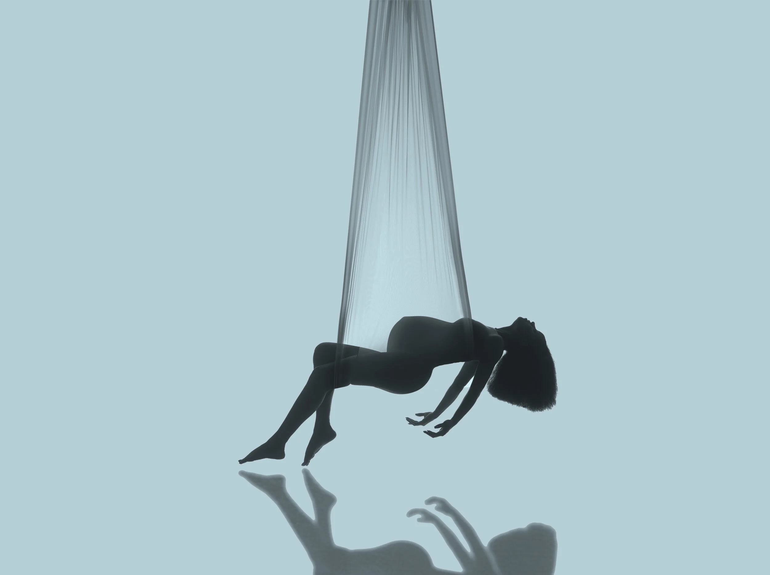 Dramatic aerial silk maternity silhouette with flowing fabric by Chicago maternity photographer