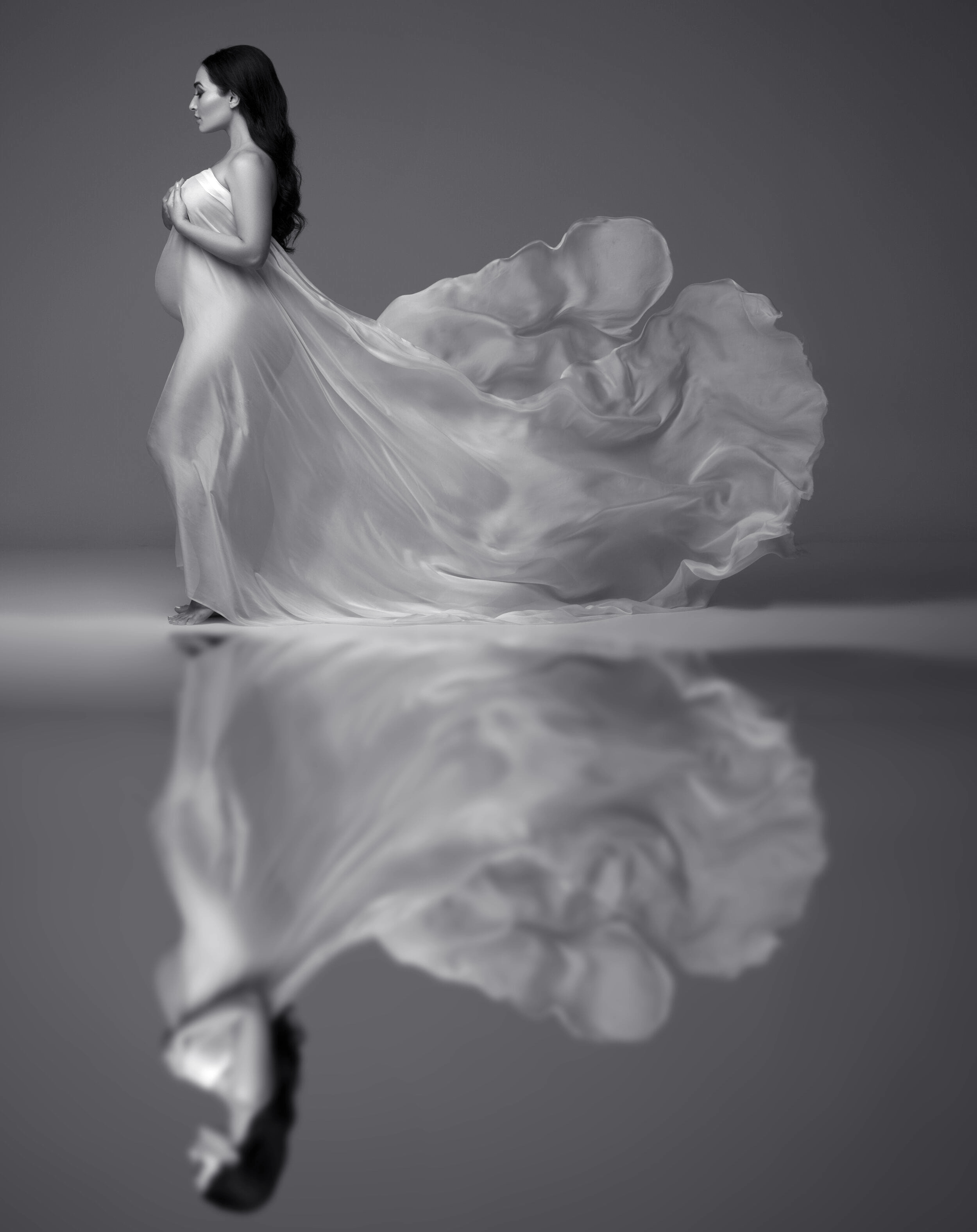 Fine-art maternity silhouette in studio with flowing silk fabric by Chicago maternity photographer